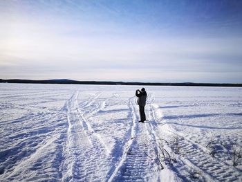 People standing in snow against sky during winter