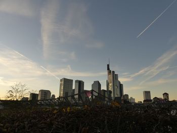 Modern buildings in city against sky during sunset