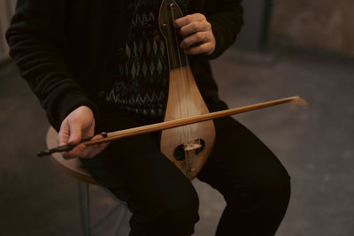 Midsection of man playing guitar