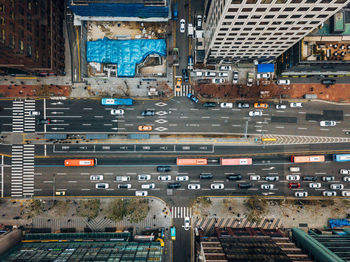 Drone view of cars on road amidst buildings in city