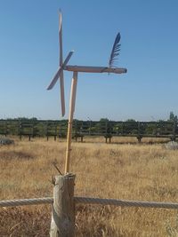 Traditional windmill on field against clear sky