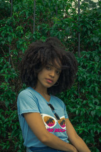 Portrait of teenage girl standing against plants