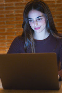 Young woman using laptop at table