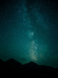 Low angle view of silhouette mountain against star field