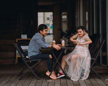 Young couple sitting on table