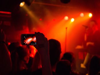 Digital composite image of man photographing music concert