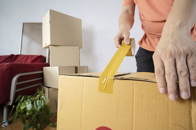 Midsection of man holding paper at home