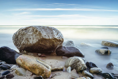 Rocks on beach against sky