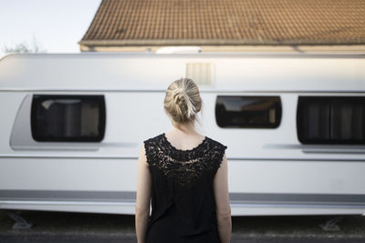 Blond woman in front of camper trailer