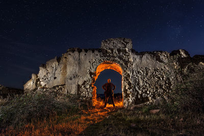 Illuminated light painting on wall against sky at night