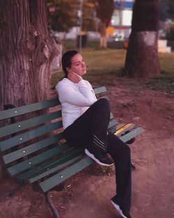 Young woman sitting on bench at park