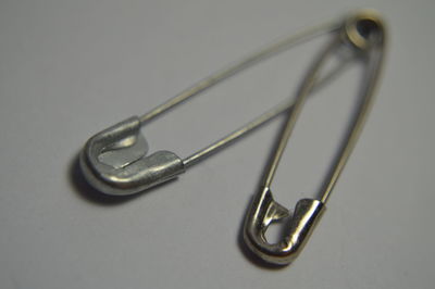 Close-up of safety pin on gray background