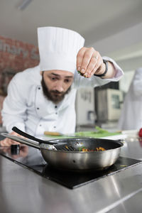 Midsection of man preparing food in kitchen