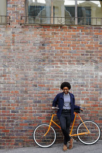 Man riding bicycle on brick wall