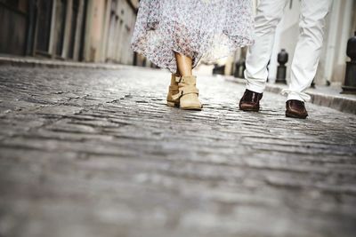 Low section of man and woman walking on street