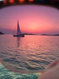 Sailboat sailing on sea against sky during sunset