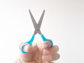 Close-up of hand holding toy against white background