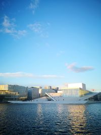 Sea by buildings in city against sky