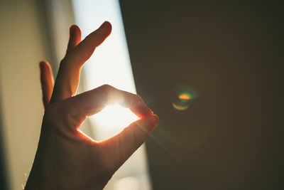 Close-up of hand gesturing against window