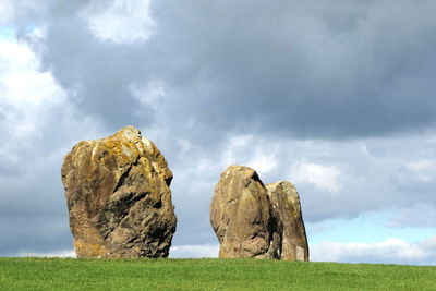 Rocks on field against sky