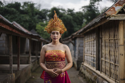 Portrait of mature man standing outside temple against building