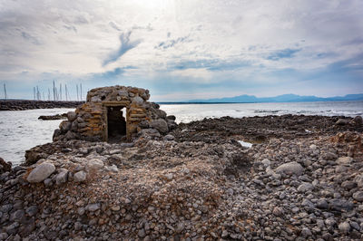 Scenic view of rocks on beach against sky