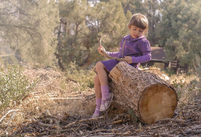 Full length of cute girl sitting outdoors