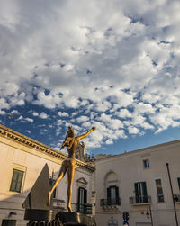 Low angle view of statues on building against sky