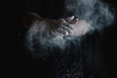 Close-up of man hand against black background