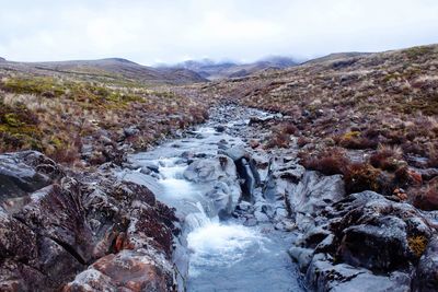 Scenic view of waterfall against sky