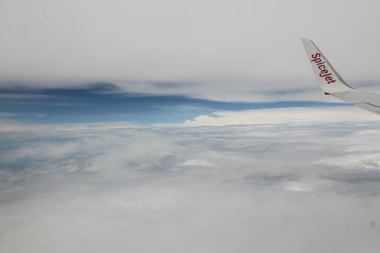 sky, cloud - sky, scenics, low angle view, copy space, flying, beauty in nature, tranquility, nature, cloud, mountain, weather, tranquil scene, cloudy, mid-air, day, outdoors, white color, airplane, part of