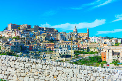 Buildings in city against blue sky