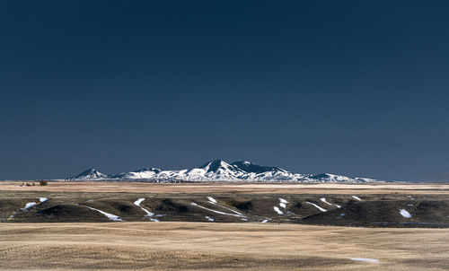 Scenic view of snowcapped mountains against clear sky during winter