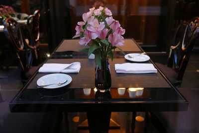 Flower in vase on dining table at restaurant