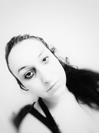 Portrait of young woman against white background