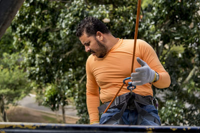 Man on a rappel rope looking down