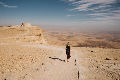 People on desert against sky