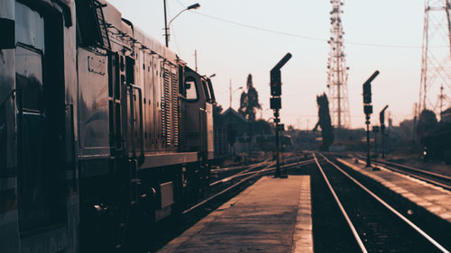 Train at railroad station against sunrise