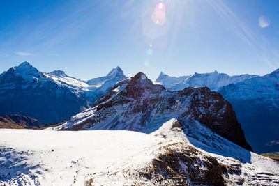 Scenic view of snowcapped mountains against blue sky