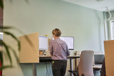 Rear view of woman using computer in office