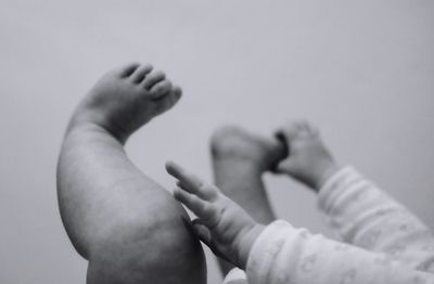 Low section of newborn lying against wall