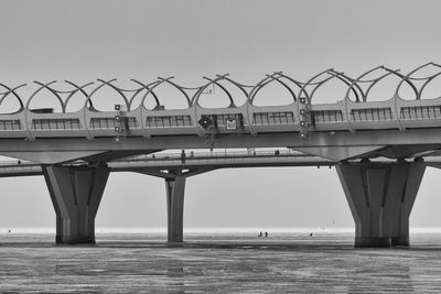 Bridge over sea against clear sky