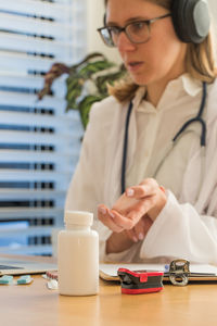 Young woman using mobile phone on table