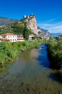 Buildings by mountain against blue sky