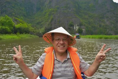 Portrait of woman in hat against lake