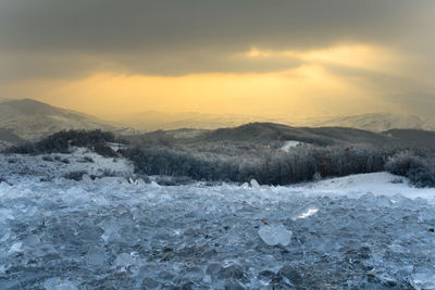 Scenic view of snowcapped mountains against sky during sunset