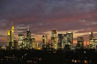Illuminated cityscape against sky at night