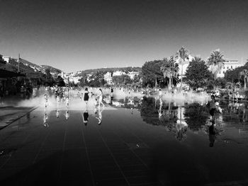 People in water against clear sky