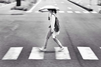 Full length of woman walking on footpath in city