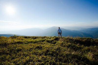 Man on field against mountain range